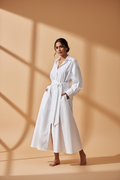 Model wearing a white oversized poplin shirt dress with a tie waist
